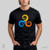 Model w czarnej koszulce słowiańskiej z nadrukiem projektu graficznego TRISKELION, Trzy spiralne wiry w kolorach: pomarańczowym, niebieskim i żółtym, ułożone w kole.