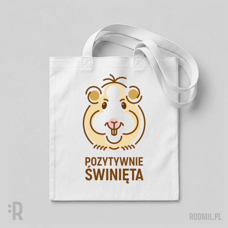 Pozytywnie świnięta - torba z nadrukiem Biała torba na ramię z humorystycznym nadrukiem projektu graficznego uśmiechniętej kremowej świnki morskiej z kitką na głowie i napisem POZYTYWNIE ŚWINIĘTA.