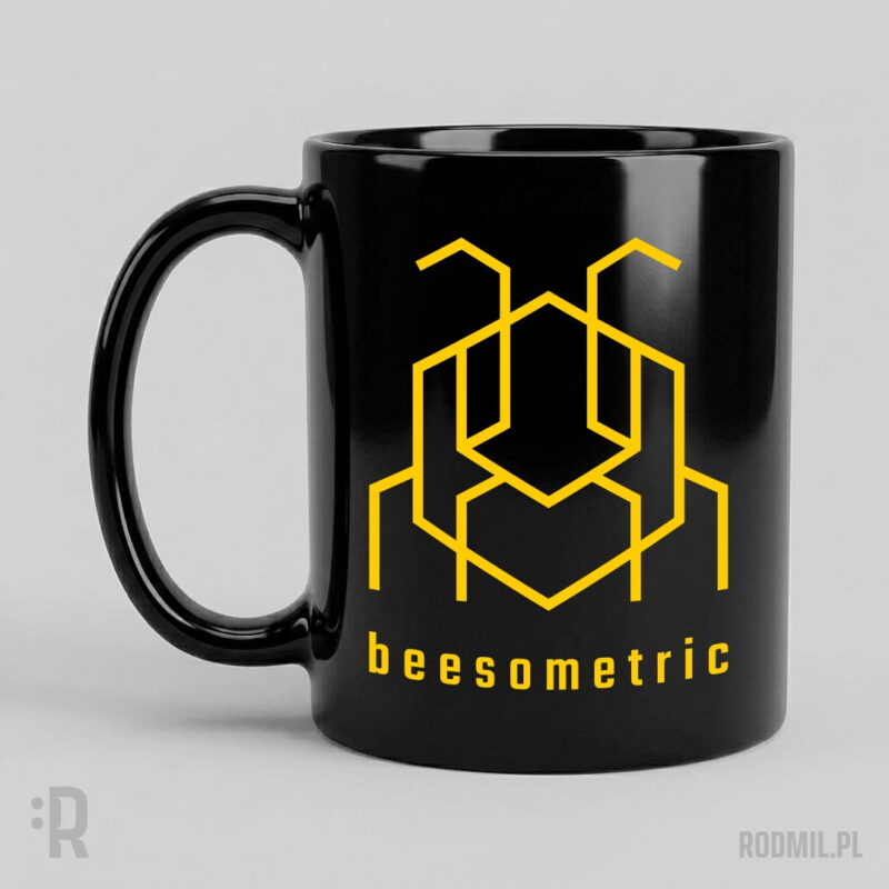 Beesometric - kubek z nadrukiem Czarny kubek z nadrukiem projektu graficznego żółtej, konturowej, geometrycznej, heksagonalnej pszczoły i napisem pod nią BEESOMETRIC.