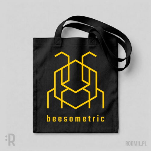 Beesometric - torba z nadrukiem Czarna torba na ramię z nadrukiem projektu graficznego żółtej, konturowej, geometrycznej, heksagonalnej pszczoły i napisem pod nią BEESOMETRIC.