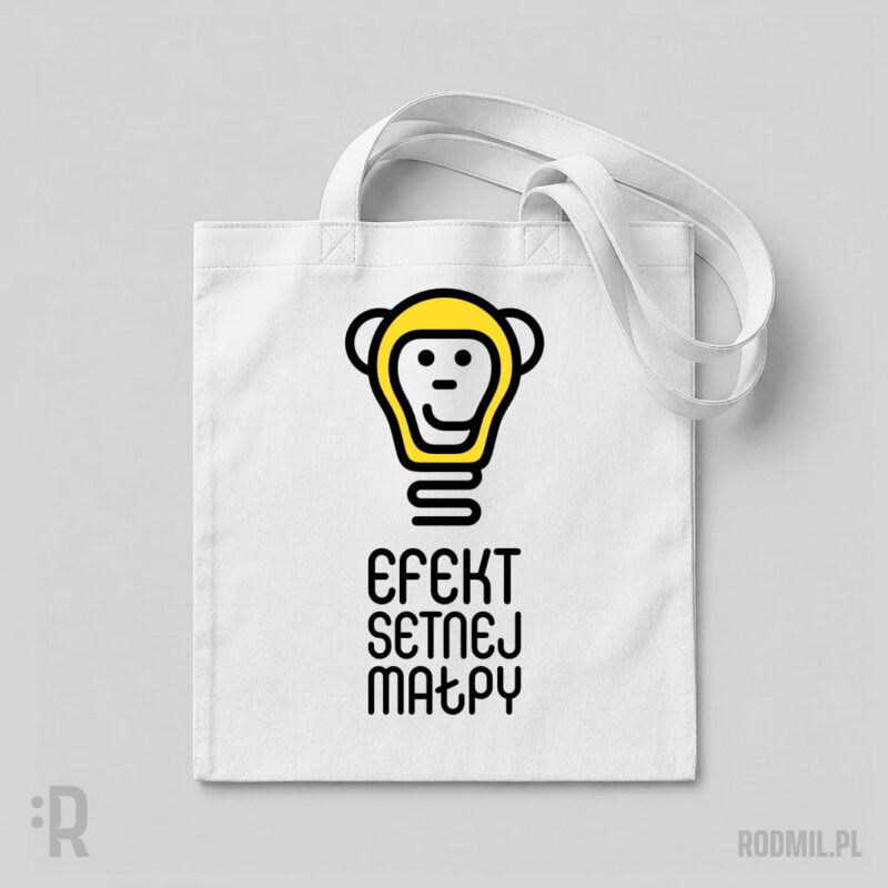 Efekt setnej małpy 2 - torba społeczna z nadrukiem Biała torba na ramię z humorystycznym nadrukiem projektu graficznego uśmiechniętej małpiej głowy w formie świecącej na żółto żarówki z podpisem EFEKT SETNEJ MAŁPY.